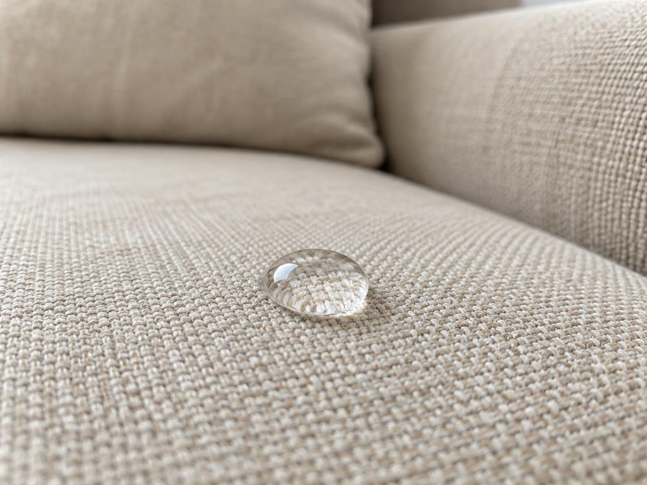 Gota de água sobre tecido de sofá bege impermeabilizado